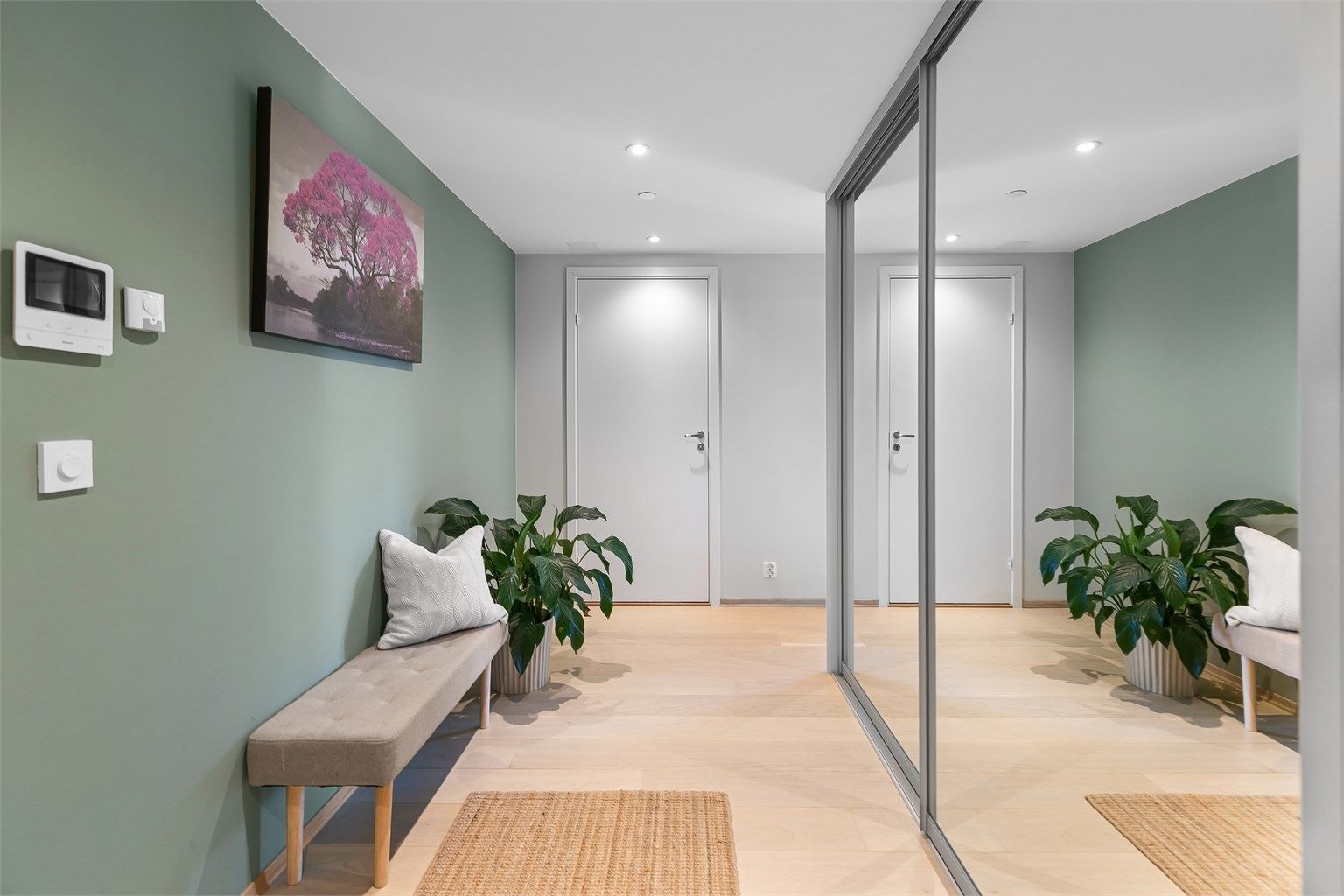 Romslig entré med downlights i himling og vannbåren gulvvarme.