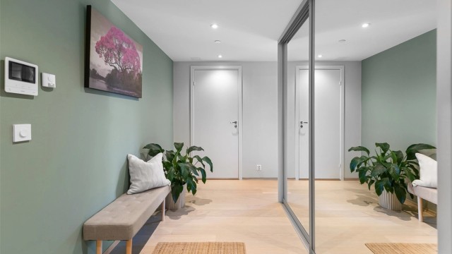 Romslig entré med downlights i himling og vannbåren gulvvarme.