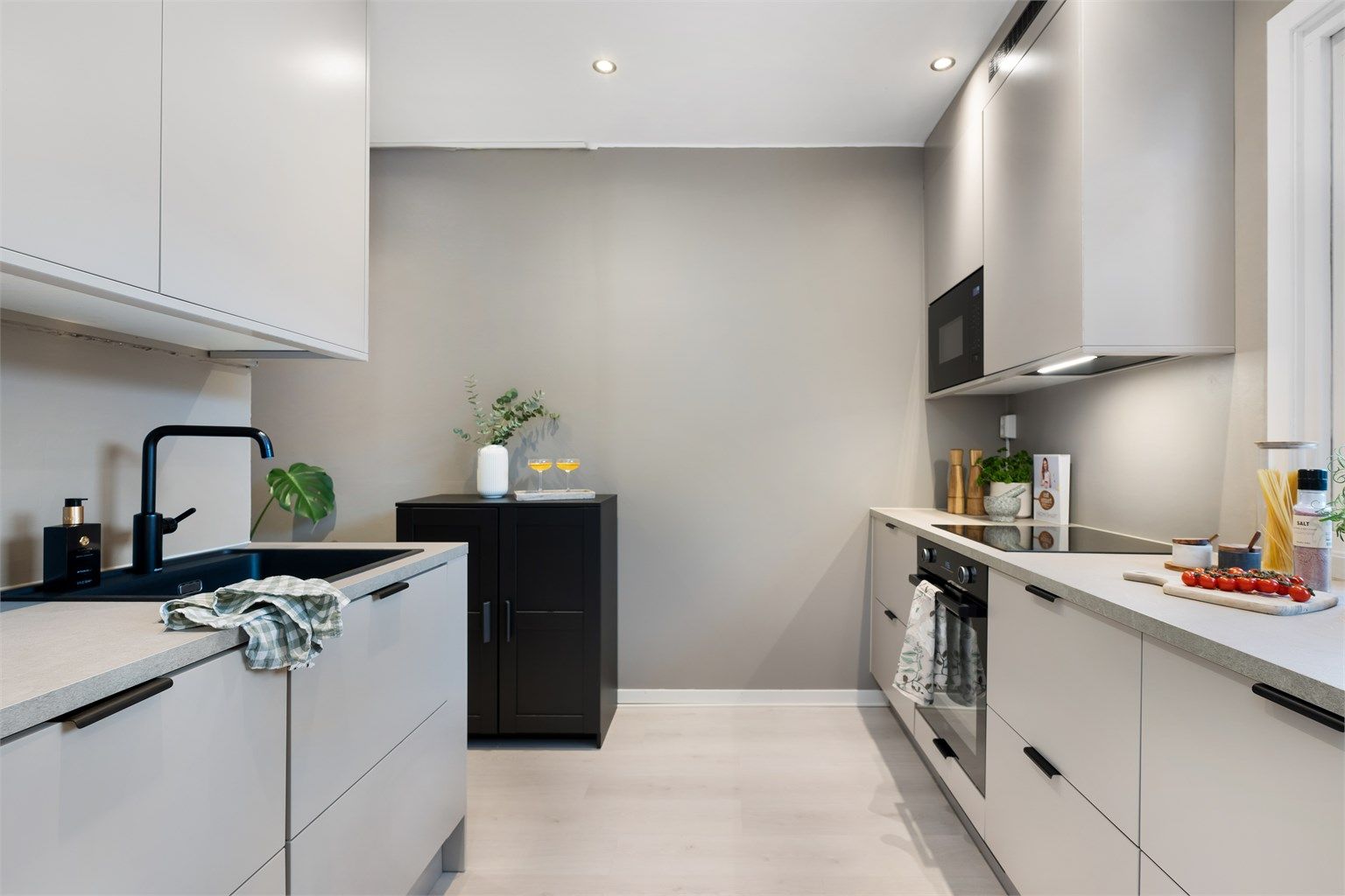 Gjennomført lekkert kjøkken fra Epoq (2023) med glatte fronter og benkeplate av laminat. Ventilator i overskap.