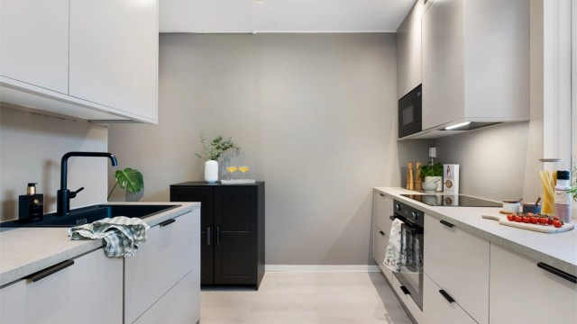 Gjennomført lekkert kjøkken fra Epoq (2023) med glatte fronter og benkeplate av laminat. Ventilator i overskap.