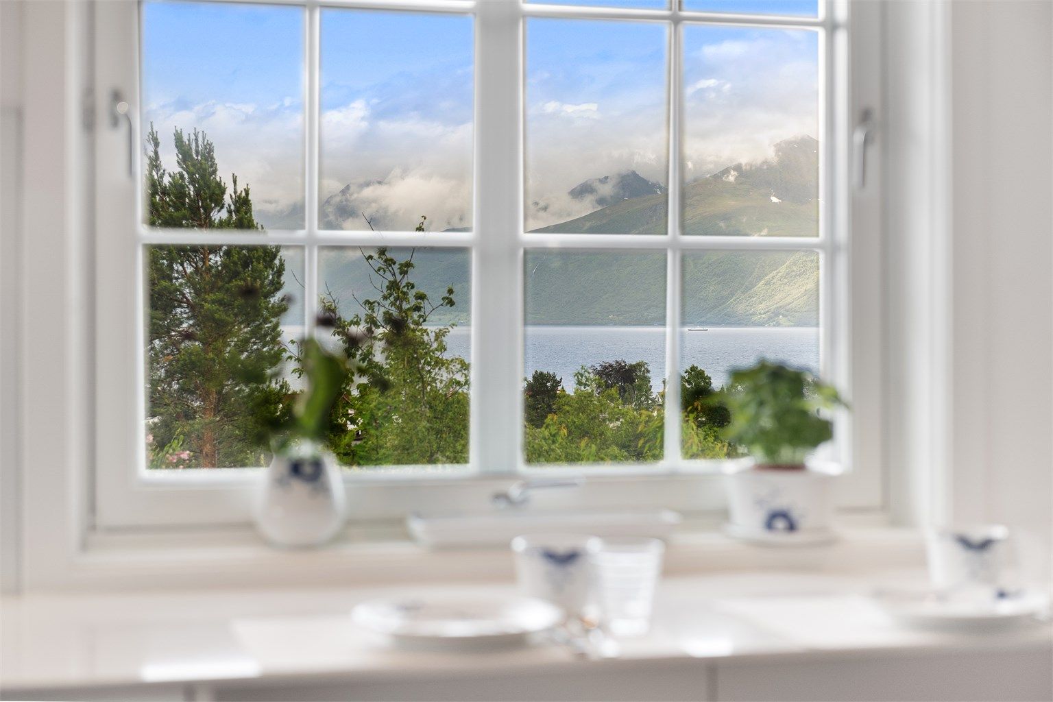 Fra vinduene kan du nyte utsikten mot fjord og fjell.