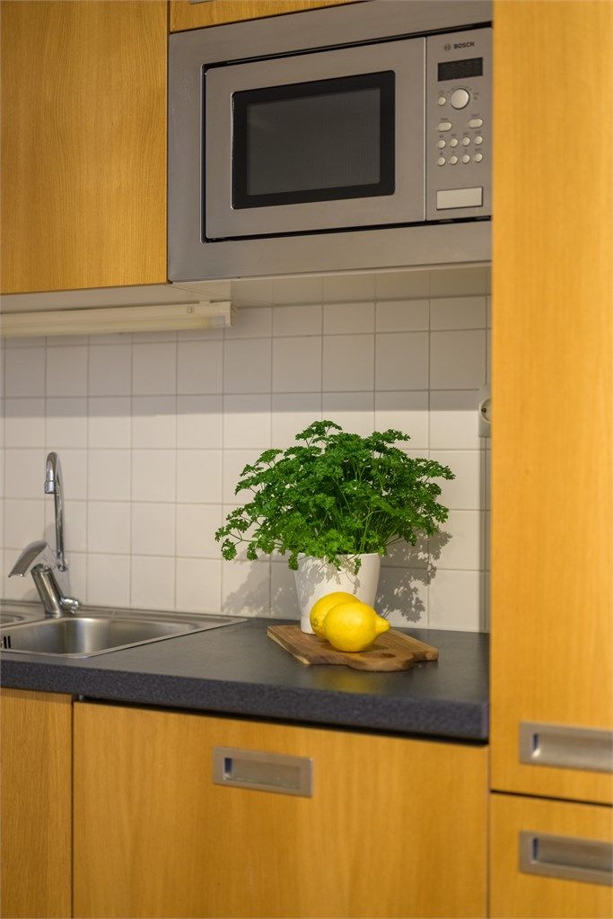 Kjøkkenet har slette fronter og ekstra høye overskap, og er utstyrt med integrert stekeovn, koketopp, oppvaskmaskin, kjøleskap og mikrobølgeovn.