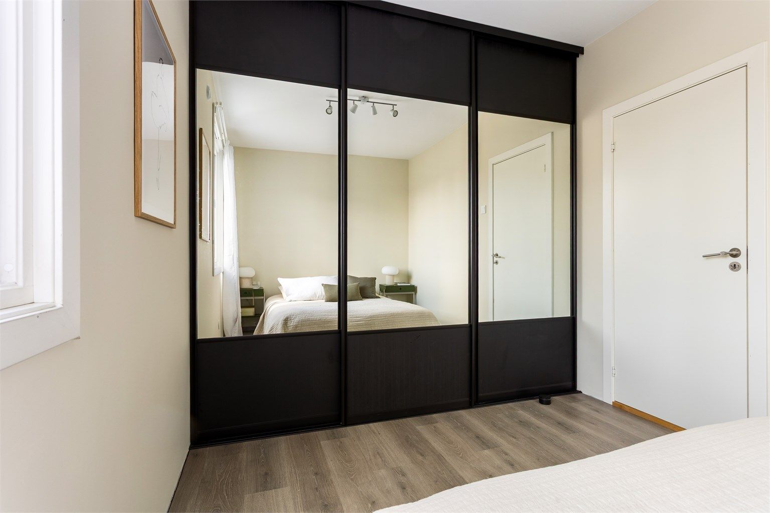 En stor skyvedørsgarderobe med speilfronter gir rikelig med oppbevaringsplass.