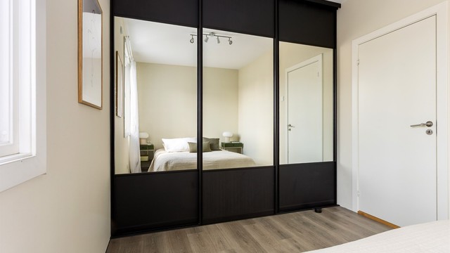 En stor skyvedørsgarderobe med speilfronter gir rikelig med oppbevaringsplass.