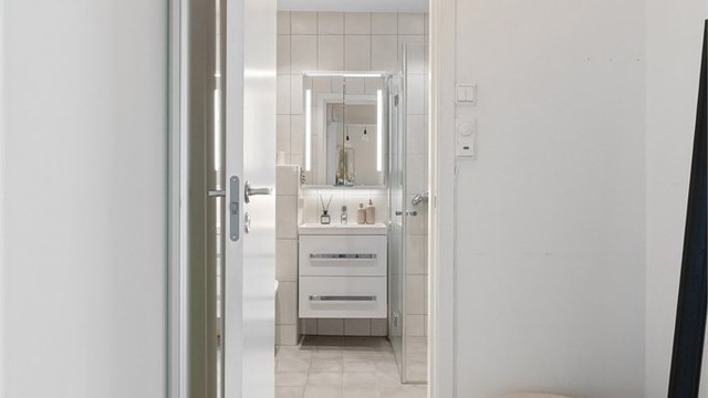 Gang mellom baderom og spisestuen. Innredet med plassbygde garderobeskap til ekstra oppbevaring