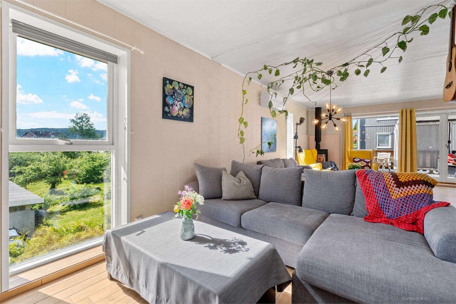 Romslig vinkelstue med to sofaområder, sittegruppe og spiseplass