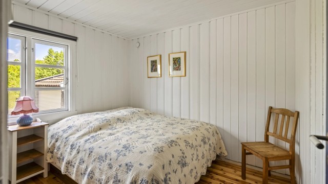 Hyttas hovedsoverom har en praktisk skyvedørsgarderobe for oppbevaring.