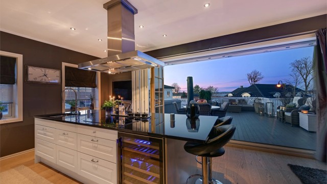 Fra kjøkken/spisestue er det montert store skyvedører/terrassedører som leder ut til en svært delikat terrasse med gode solforhold og med god plass til både sittegrupper og solsenger.