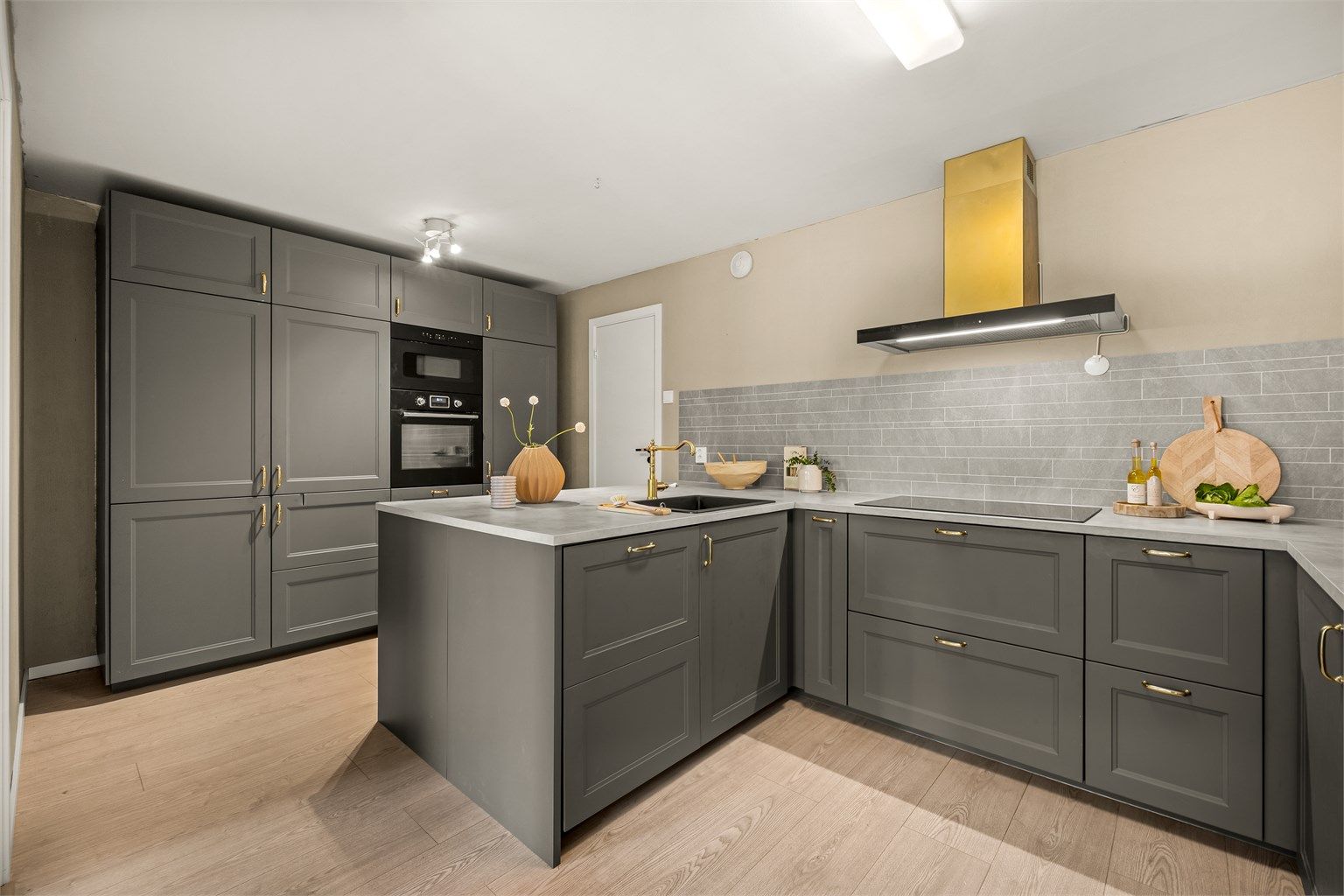 Moderne kjøkkeninnredning med profilerte fronter og rikelig med skap- og benkeplass.