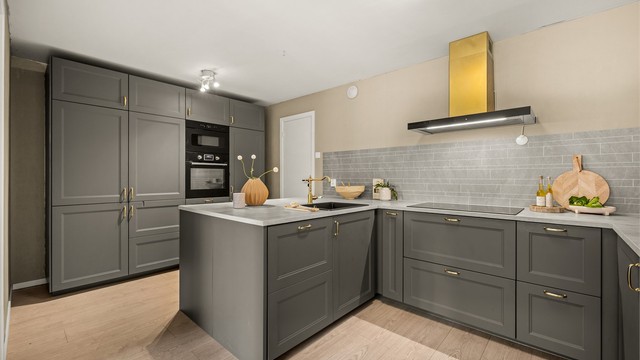 Moderne kjøkkeninnredning med profilerte fronter og rikelig med skap- og benkeplass.