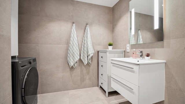 Badet har downlights i tak, varmekabler og opplegg for vaskemaskin.