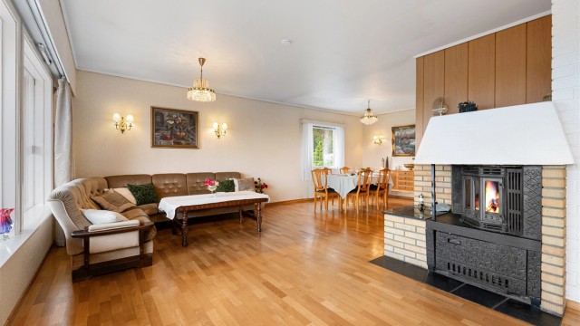 Stuen har god plass til både sofagruppe og en egen spisestuedel. Gulvet har parkett.