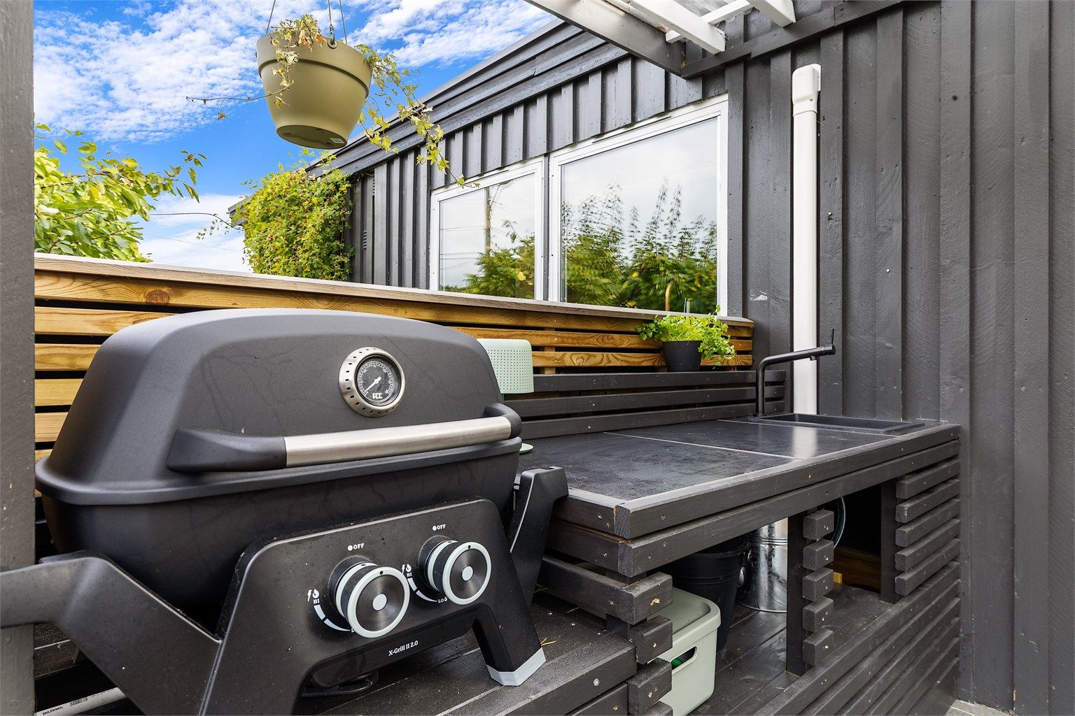 Praktisk utekjøkken på terrassen med grill og arbeidsbenk.