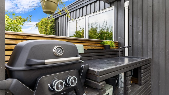 Praktisk utekjøkken på terrassen med grill og arbeidsbenk.