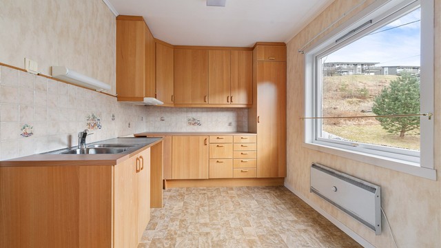 Kjøkkenet i første etasje har en innredning med finerfronter, trolig fra 1980-tallet