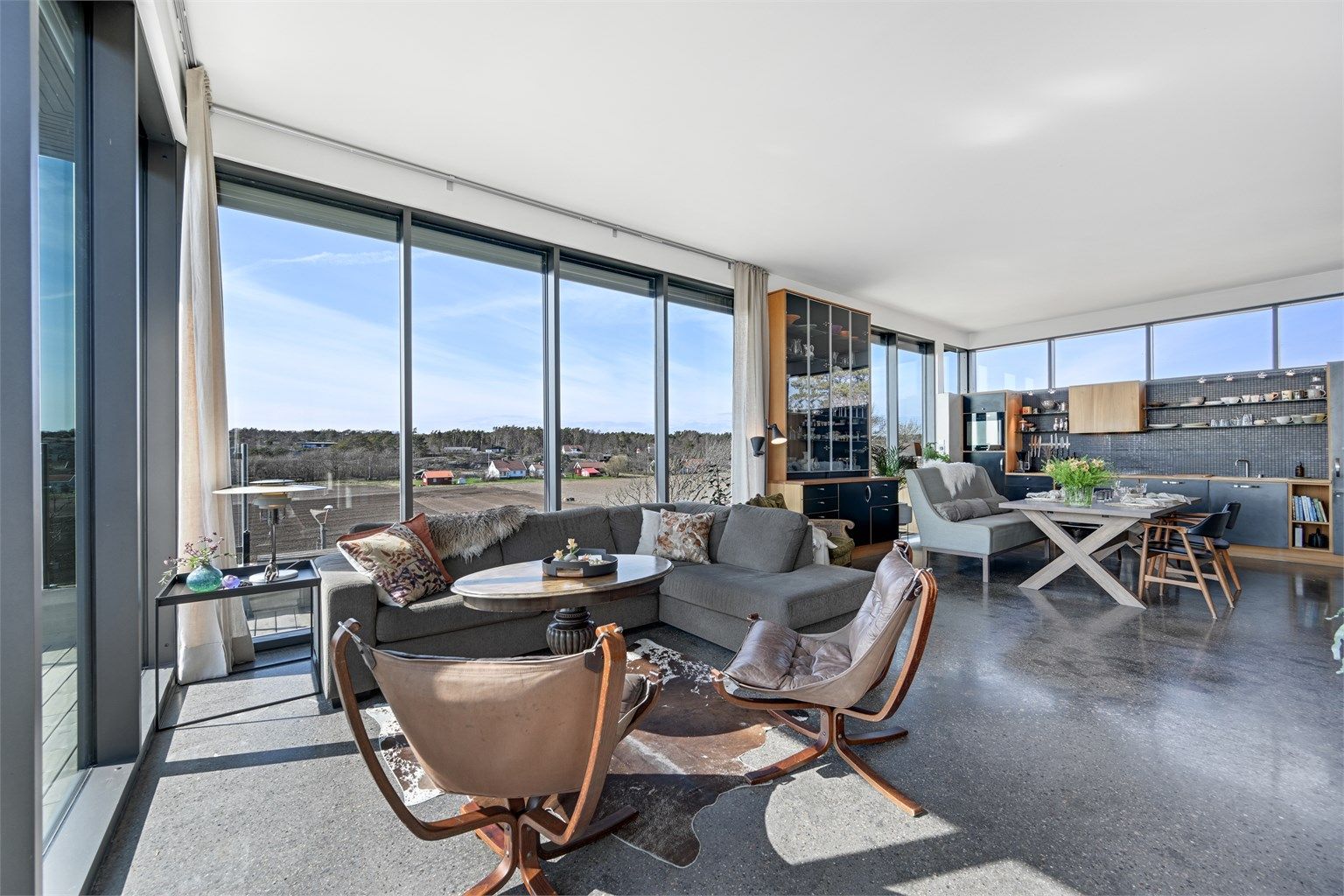 Det åpne allrommet har en gjennomgående materialbruk med heltre eik og slipt betong på gulv.