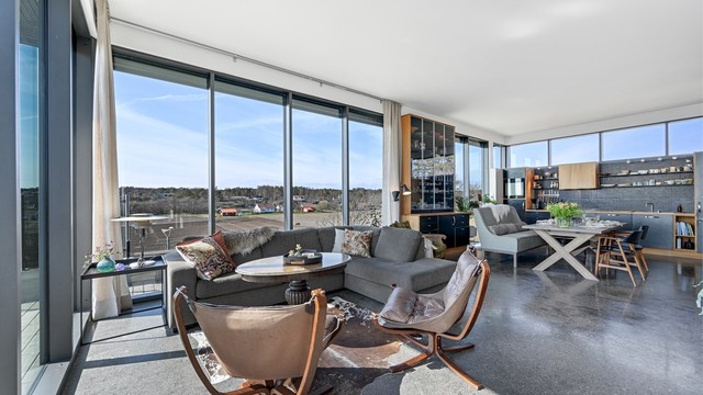 Det åpne allrommet har en gjennomgående materialbruk med heltre eik og slipt betong på gulv.