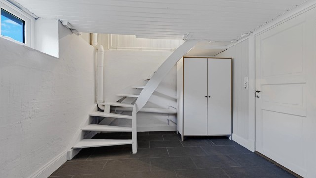 I kjelleren er det trapperom, bad/vaskerom, soverom, soverom/trimrom, kott og bod. Kjelleretasjen er ikke omsøkt fra tilleggsdel til hoveddel, samt at takhøyden er lavere en dagens krav til takhøyde for rom til varig opphold.