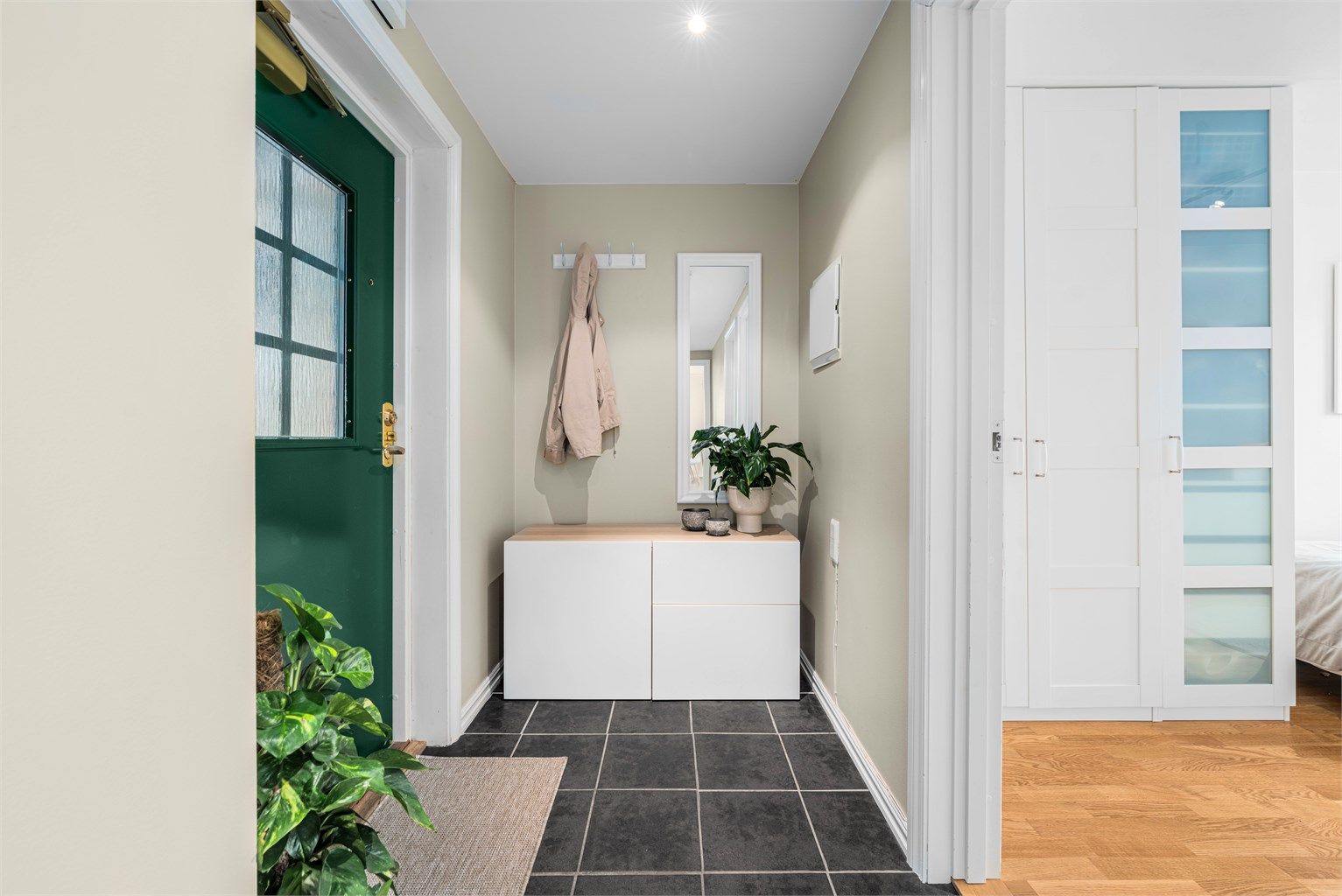 Vel inne blir vi ønsket velkommen i en pen entré med lysmalte vegger og gulv med gulvvarme. Det er fin plass til oppbevaringsmøblement i entreen, og mer plass til yttertøy og utstyr finnes i en tilliggende innebod. 