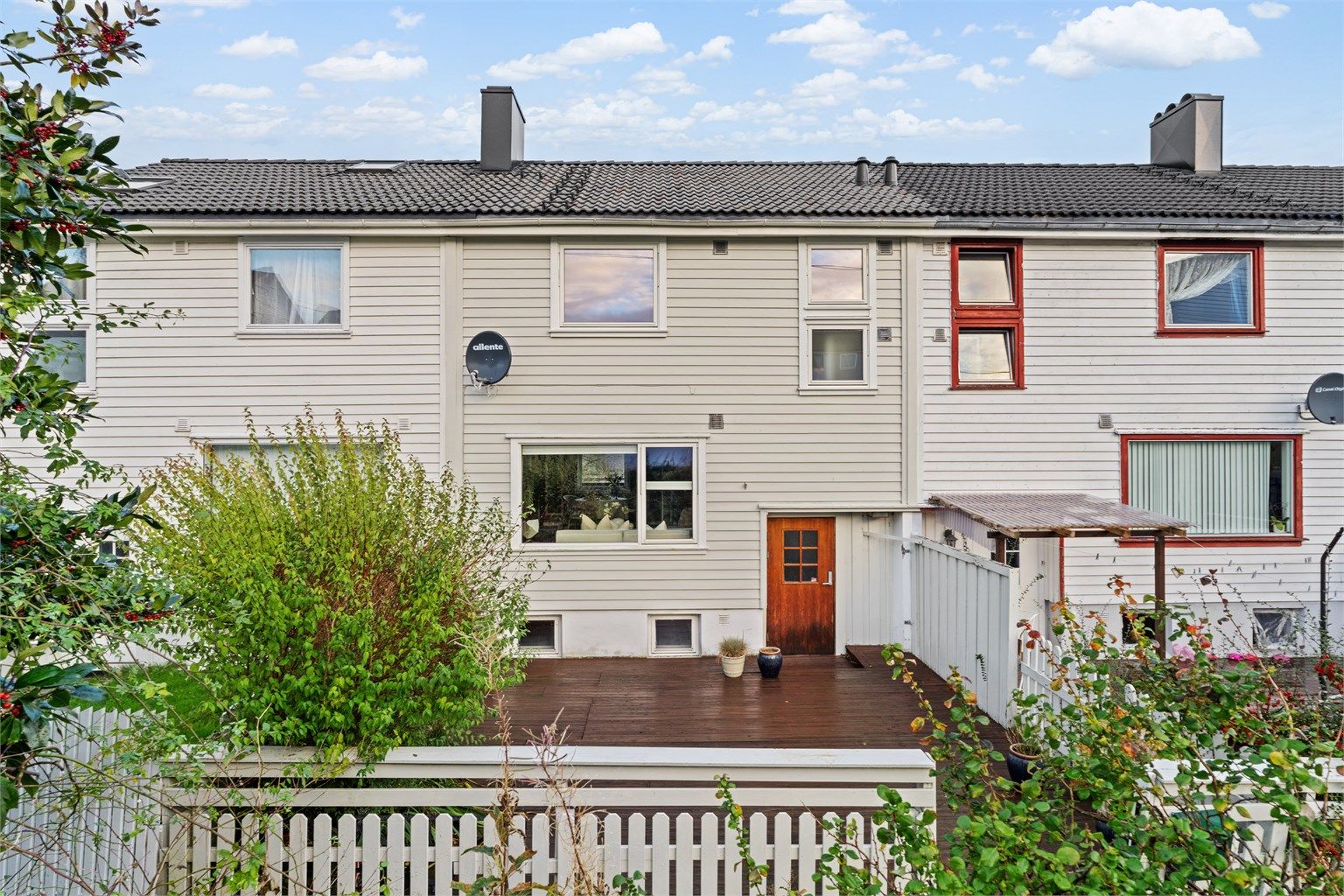 Rekkehus over fire plan med stor treterrasse og parkering mot hovedvei.
Foto: Martin Nordbø