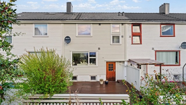 Rekkehus over fire plan med stor treterrasse og parkering mot hovedvei.
Foto: Martin Nordbø