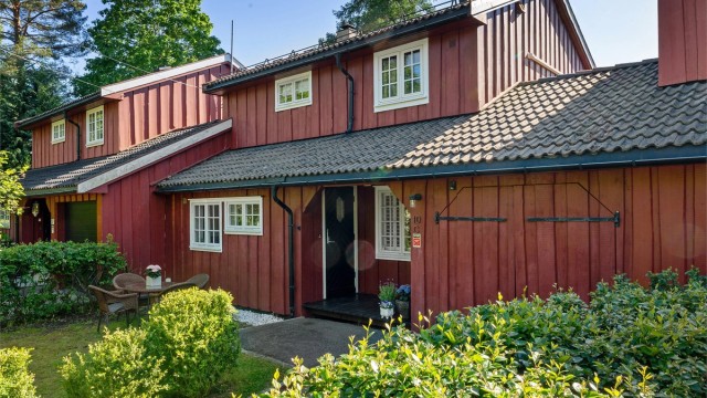 Asfaltert oppkjørsel og biloppstillingsplass foran garasjen.