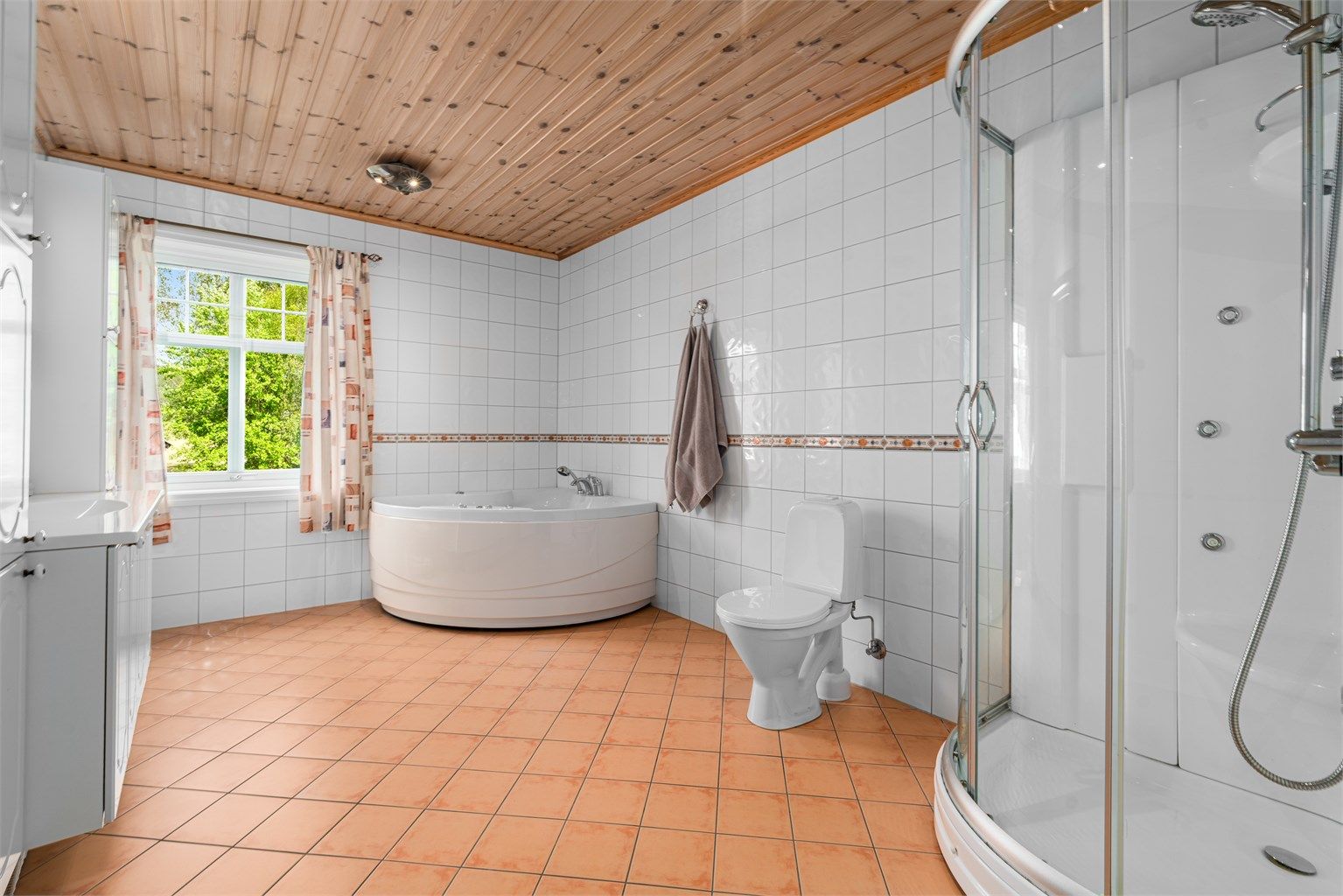 Hovedbadet i første etasje er utstyrt med både dusjkabinett og hjørne-massasjebadekar.