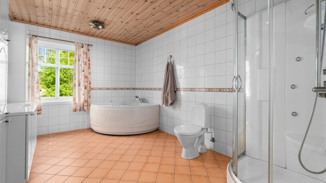 Hovedbadet i første etasje er utstyrt med både dusjkabinett og hjørne-massasjebadekar.