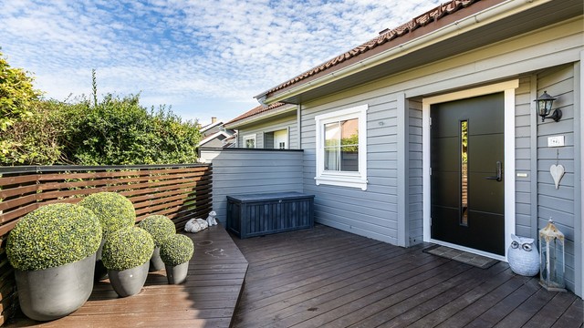 På inngangssidens tilbaketrukne terrasse kan du sitte ute i usjenerte og skjermede omgivelser.