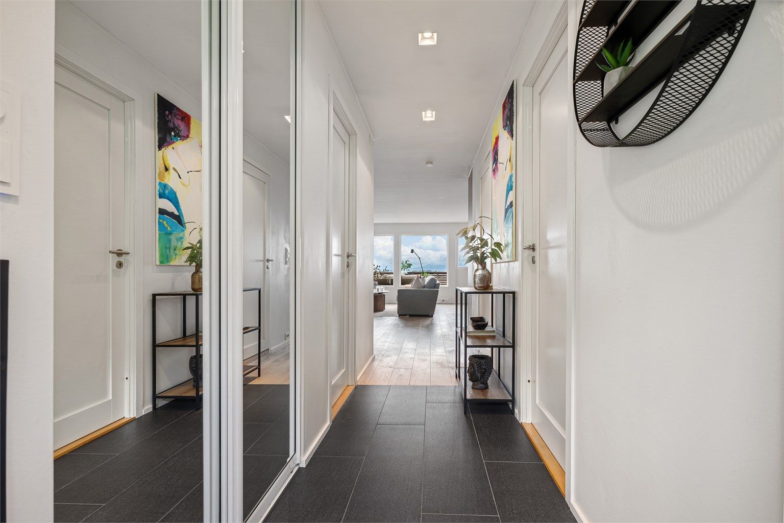 Flislagt entré/gang med varmekabler i gulv og skyvedørsgarderobe med speilfronter. Downlights i tak. Ved entré ligger begge soverom på hver sin side.
