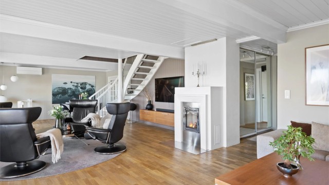 Stuen har varmepumpe fra 2023, samt hygge fra en stilig, innfelt peis med glassdør og ramme i stål.