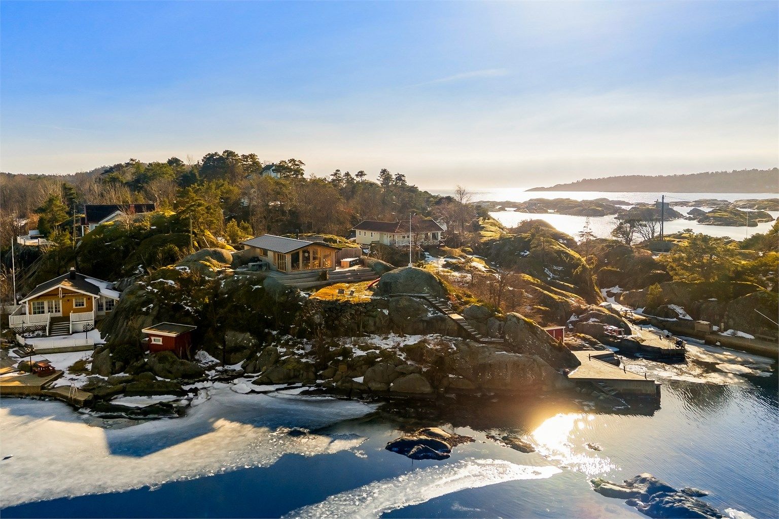 På Arøya ligger hyttene spredt i terrenget, byggestilen er varierende, de fleste med tradisjonelle smårutede vinduer. Også på denne tomten har det i sin tid stått en slik hytte, men den er for lengst revet og nå erstattet med denne moderne hytta.
