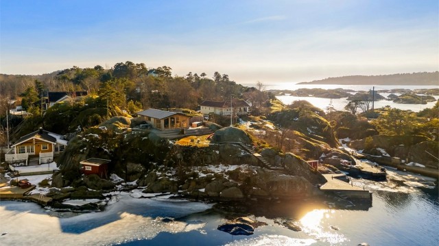 På Arøya ligger hyttene spredt i terrenget, byggestilen er varierende, de fleste med tradisjonelle smårutede vinduer. Også på denne tomten har det i sin tid stått en slik hytte, men den er for lengst revet og nå erstattet med denne moderne hytta.