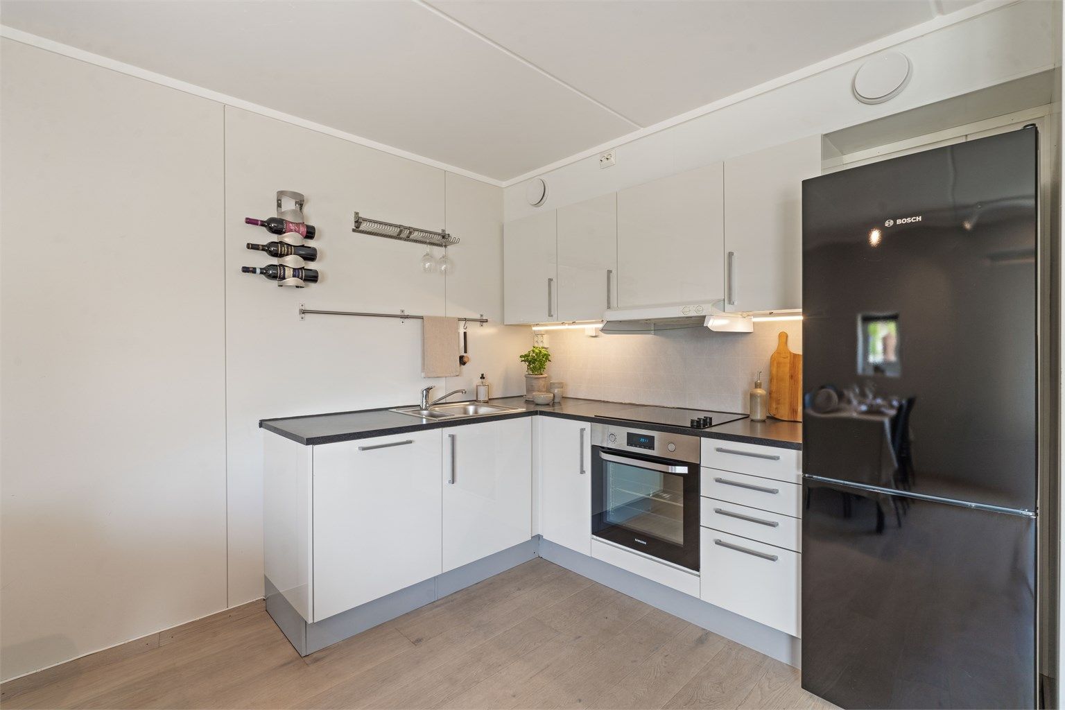 Kjøkkeninnredning med glatte fronter og benkeplate med laminert overflate.