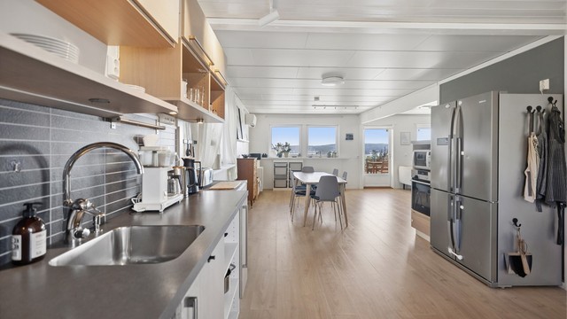 Hyggelig stue og kjøkken i åpen løsning. Tiltalende farger og moderne kjøkkenløsning.