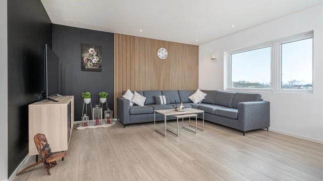 Leiligheten har en åpen stue- og kjøkkenløsning som gir en sosial og luftig atmosfære.