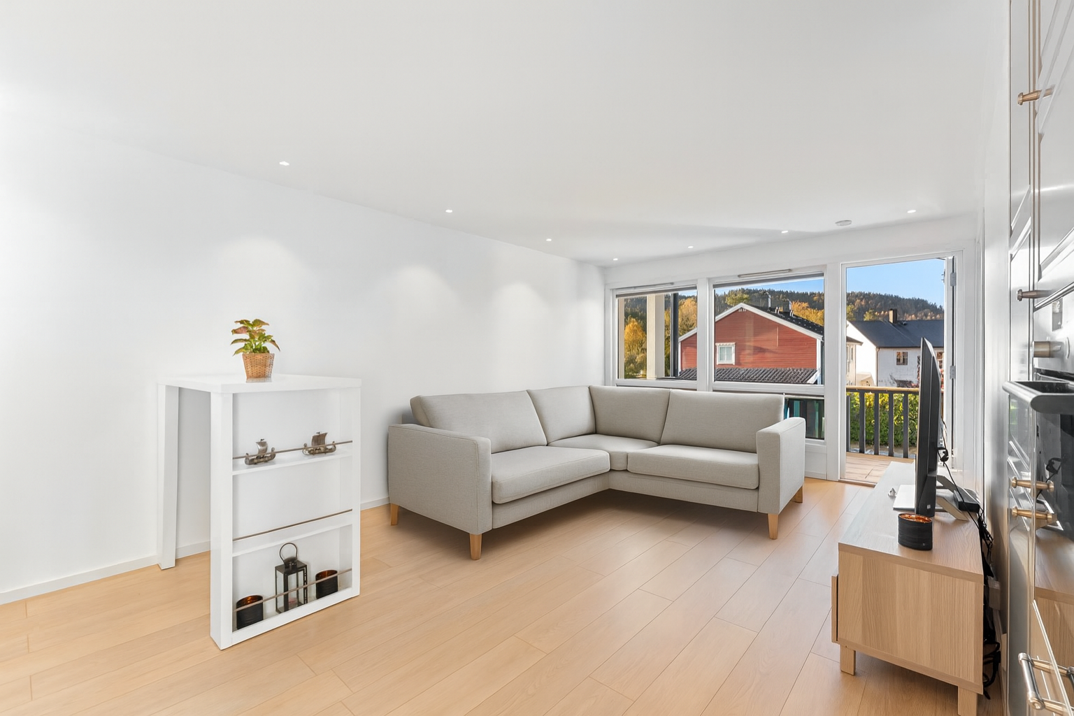 Lys og romslig stue med åpen kjøkkenløsning - Digitalt stylet sofa i stuen