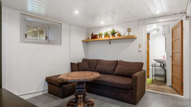 Rommet er innredet med gulvfliser med varme og downlights i himling