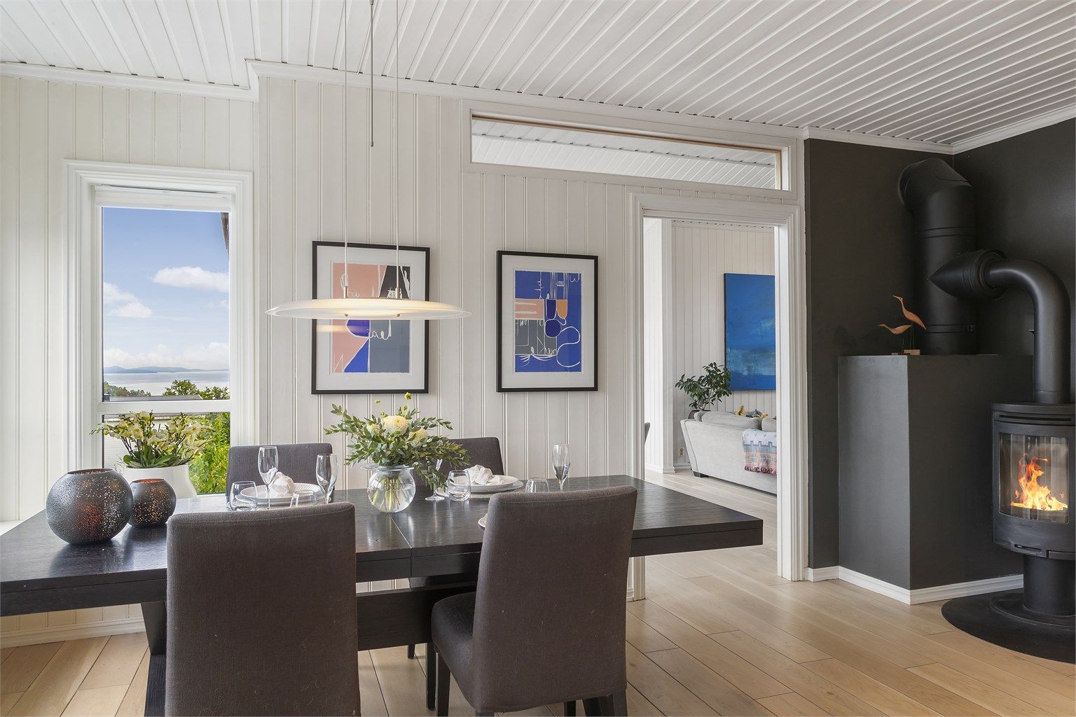 Kjøkkenet har plass til spisebord med stoler og en hyggelig peisovn er plassert i rommet. 