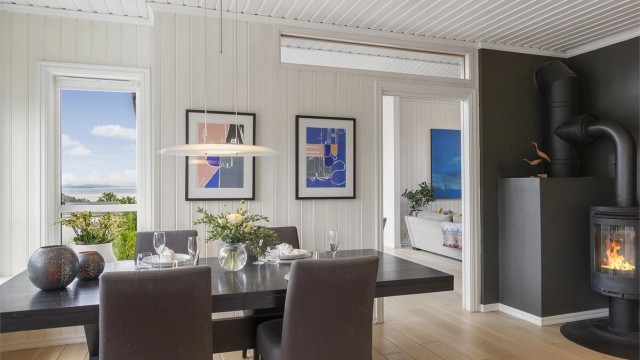 Kjøkkenet har plass til spisebord med stoler og en hyggelig peisovn er plassert i rommet.