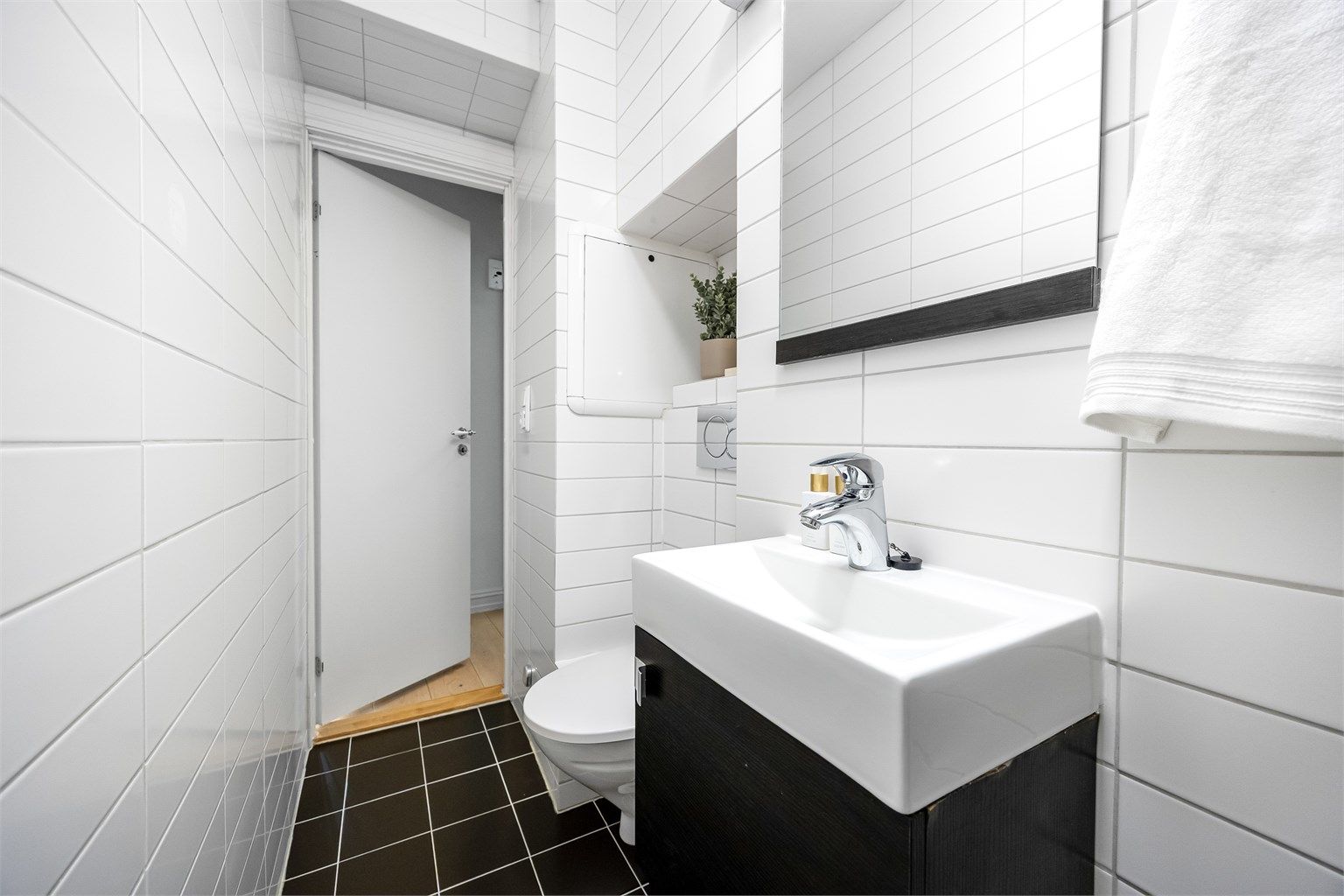 Videre er det vegghengt toalett med innebygget sisterne og praktisk nisje for ekstra oppbevaring.