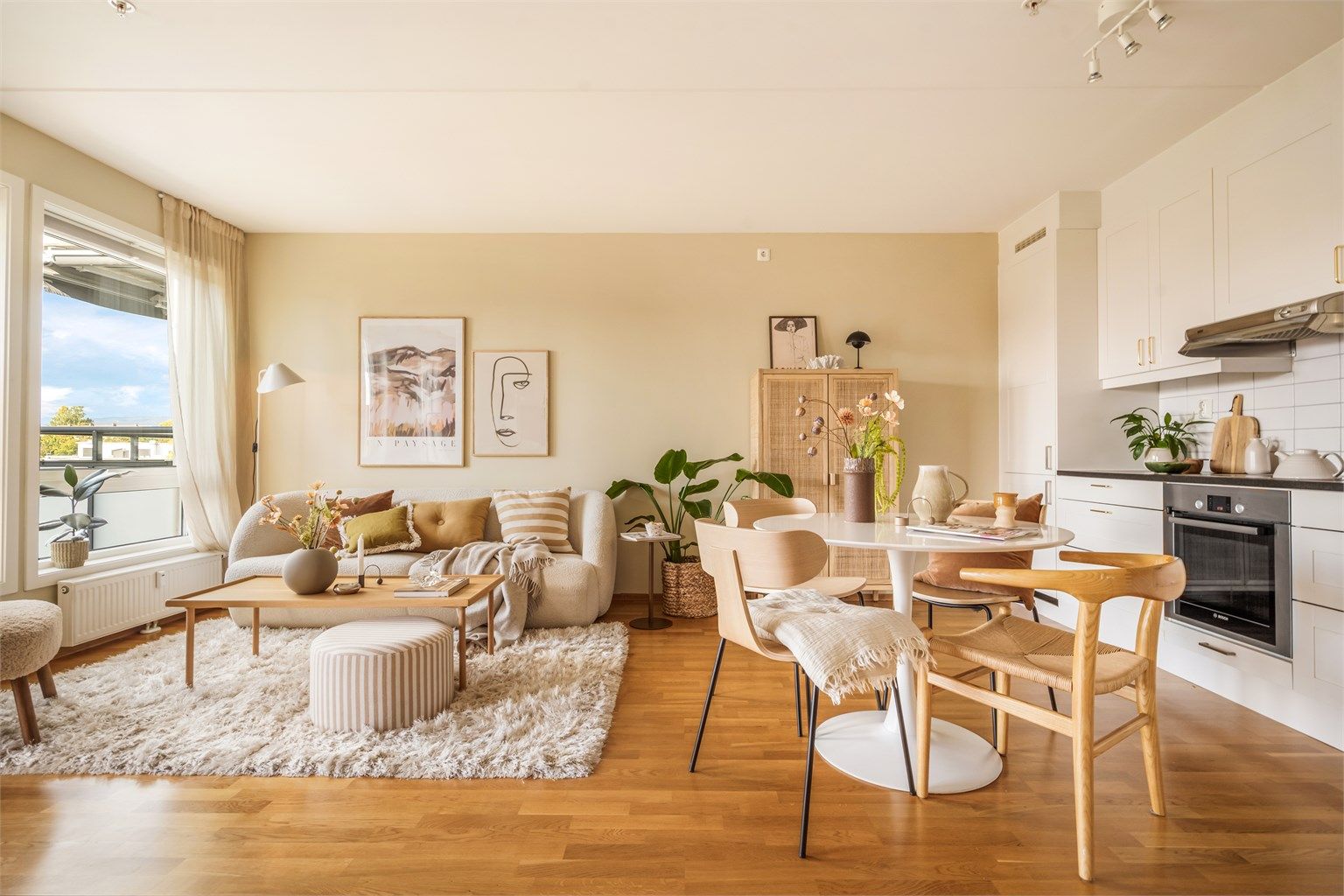 Lys og åpen stue- og kjøkkenløsning med god plass til spisebord og sofagruppe. Foto: Martine Eren Studio 