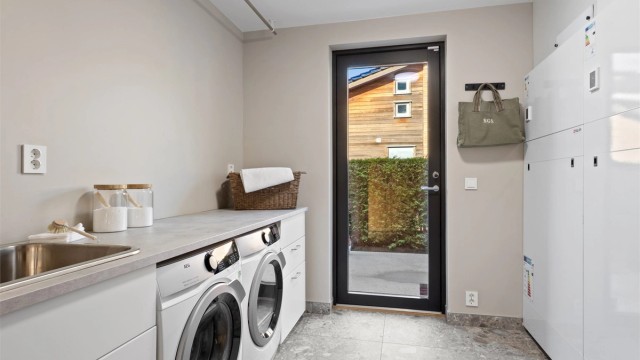 Vaskerommet inneholder arbeidsbenk med vask og opplegg for vaskemaskin og plass til tørketrommel. Rommet fungerer også som et teknisk rom med opplegg til vannbåren varme, balansert ventilasjon og sikringsskap.
