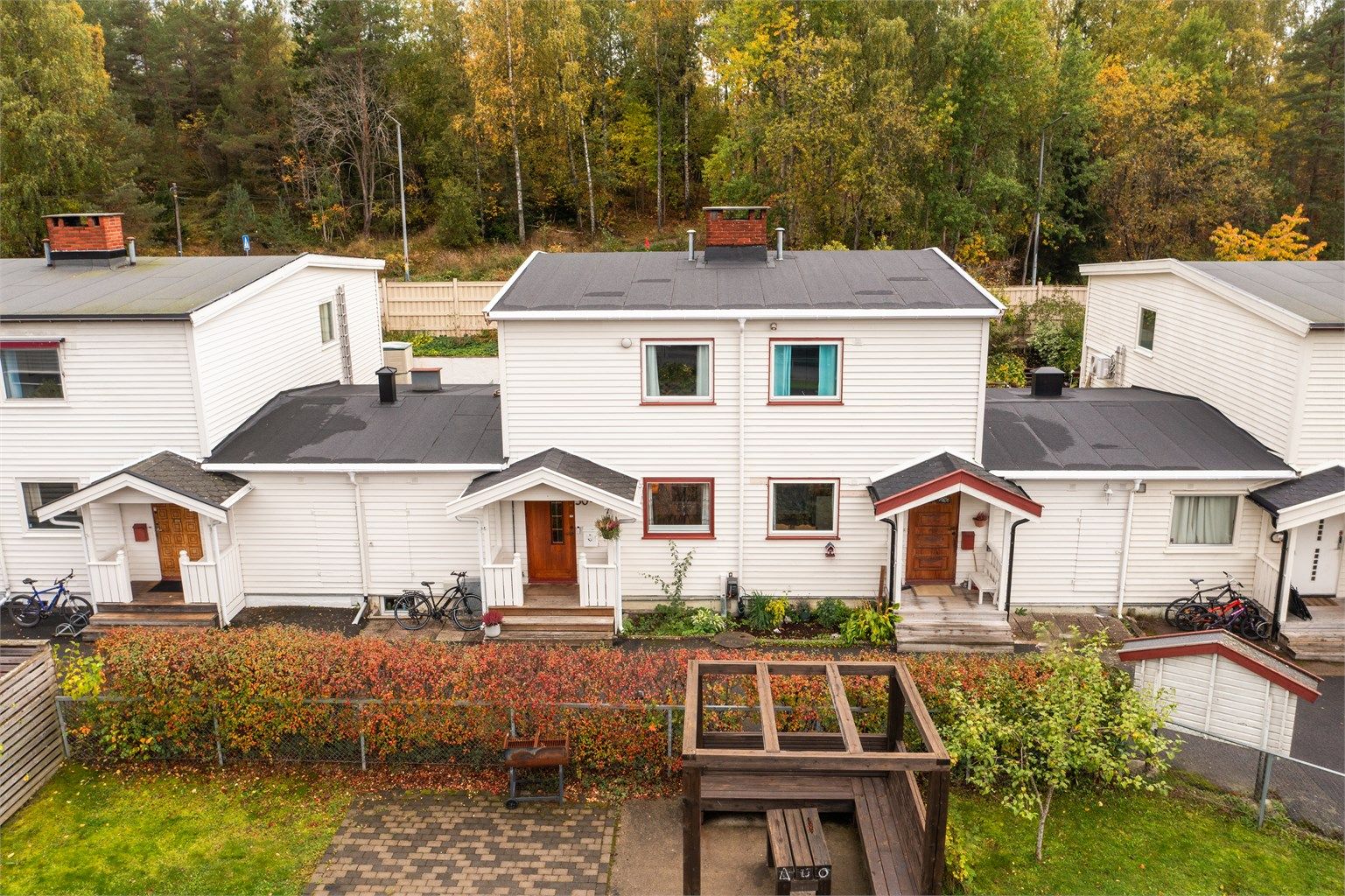 Rekkehus over tre plan med terrasse i trekonstruksjoner og garasje i fellesrekke. Foto: Martine Eren Jacobsen
