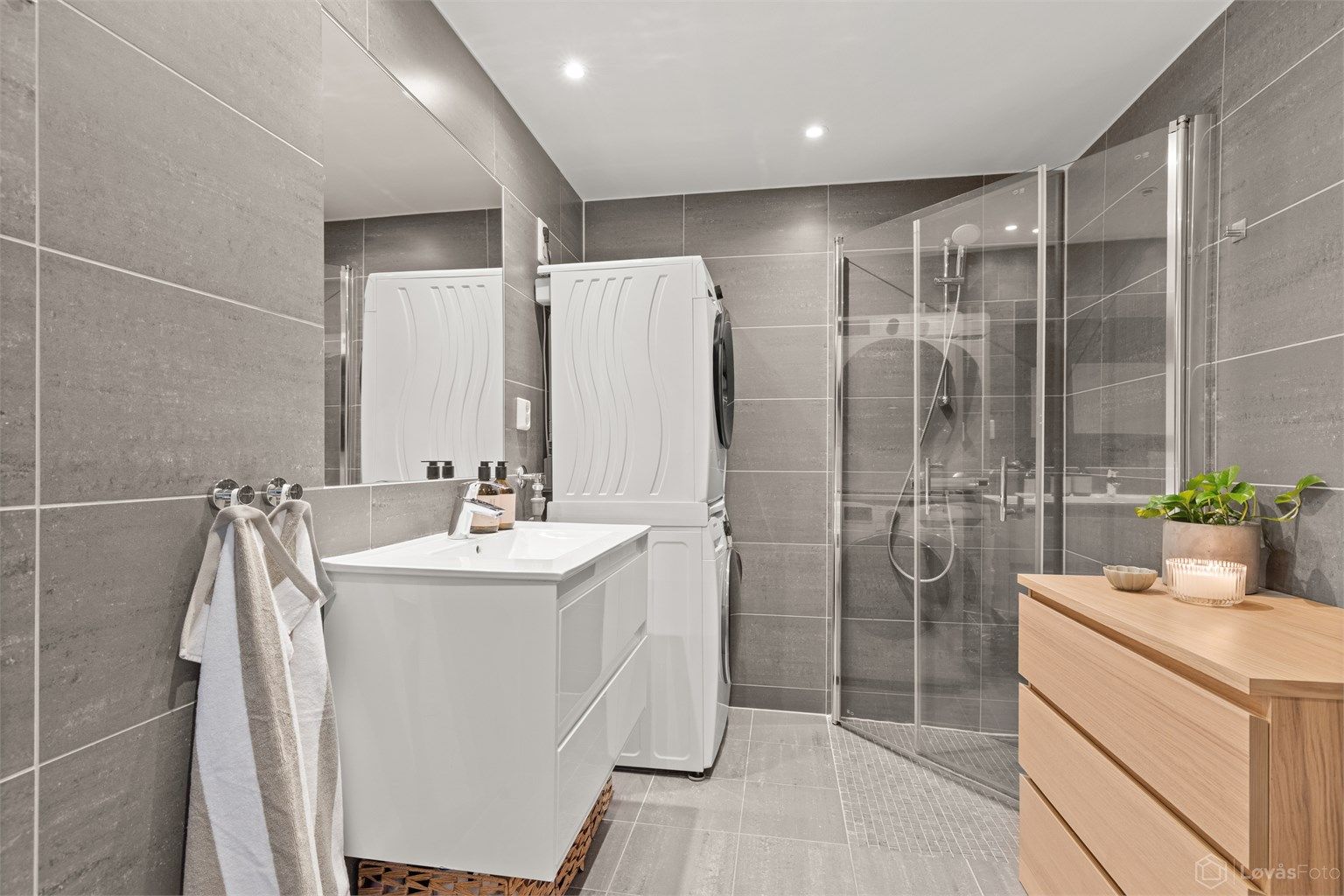 Badet er praktisk innredet med dusjhjørne med innfellbare dører og opplegg for vaskemaskin.