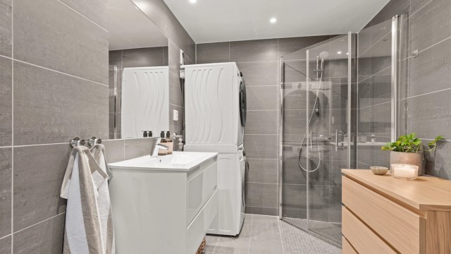 Badet er praktisk innredet med dusjhjørne med innfellbare dører og opplegg for vaskemaskin.