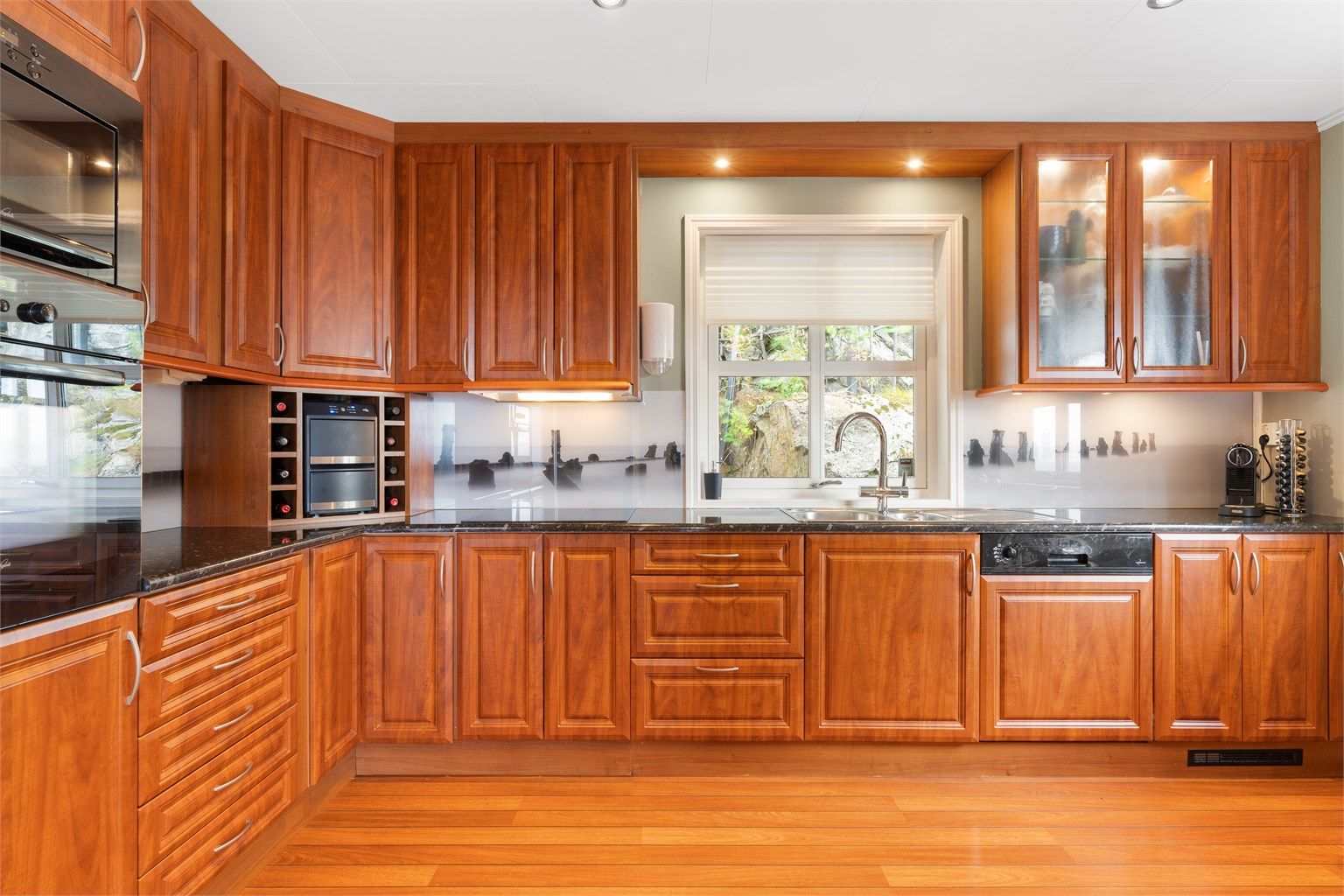 Kjøkkenet er videre innredet med integrert stekeovn, platetopp, oppvaskmaskin, mikrobølgeovn og kjøleskap med fryser.