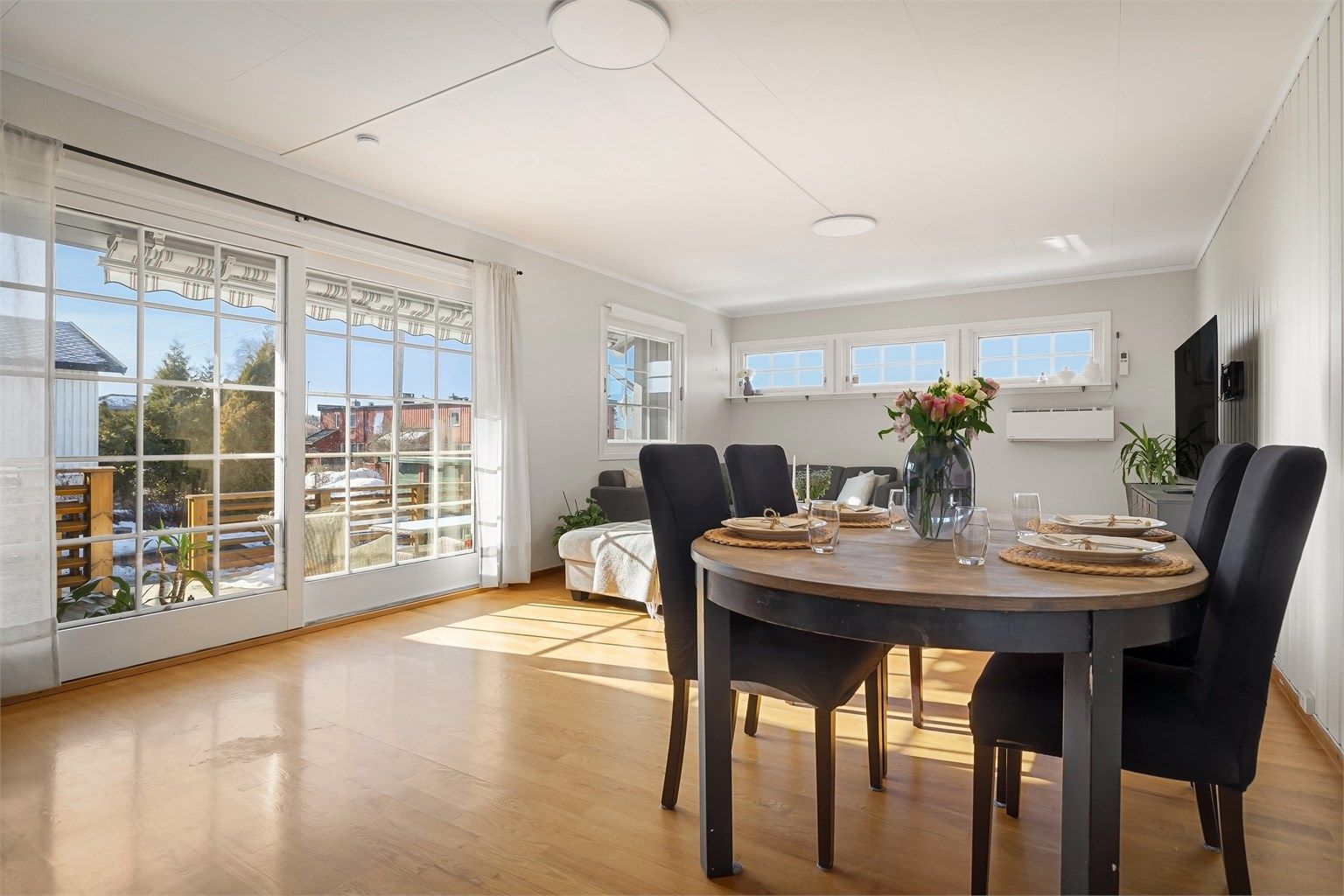 Stuen i hovedetasjen er et lyst og behagelig oppholdsrom med store vindusflater som slipper inn rikelig naturlig lys