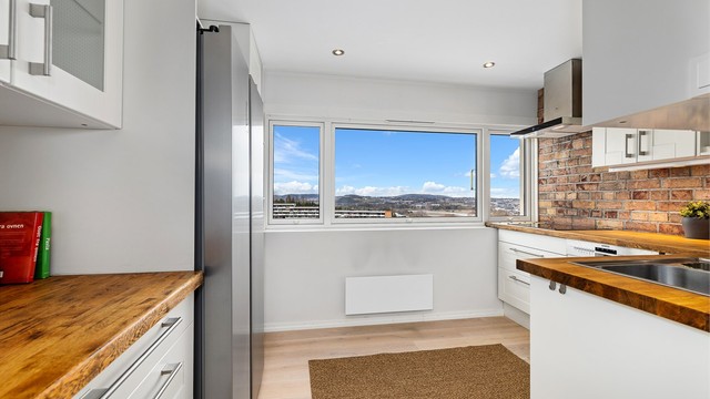 Kjøkkeninnredning fra 2010 med profilerte fronter, benkeplate i tre og en karakterfull teglsteinsvegg. Alle hvitevarer medfølger.