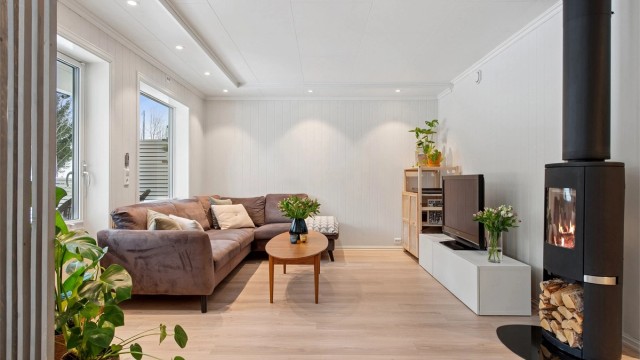 Lys og delikat stue med downlights og store vindusflater